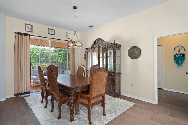 dining room featuring a notable chandelier and dark wood-type flooring