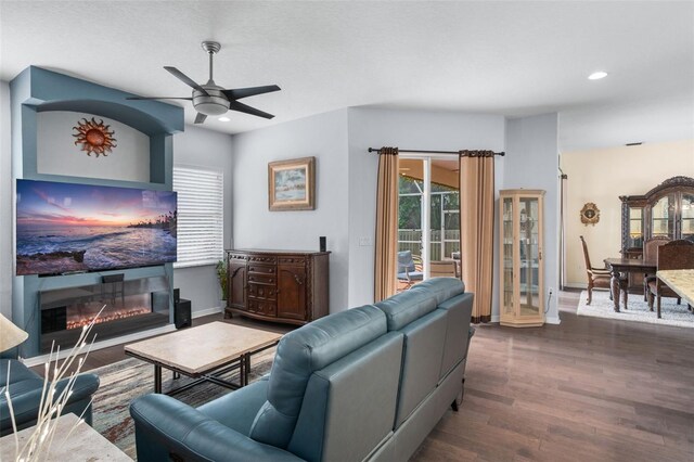 living room with ceiling fan and dark hardwood / wood-style floors