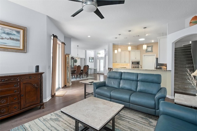 living room with dark wood-type flooring and ceiling fan