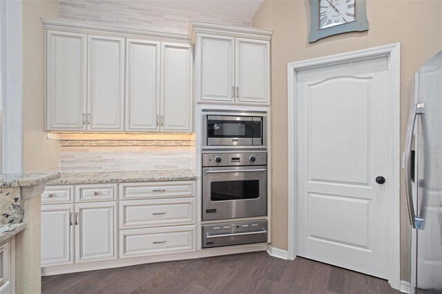 kitchen featuring light stone countertops, appliances with stainless steel finishes, and dark hardwood / wood-style floors