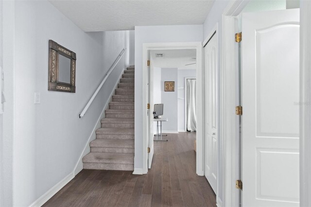 staircase featuring wood-type flooring and a textured ceiling