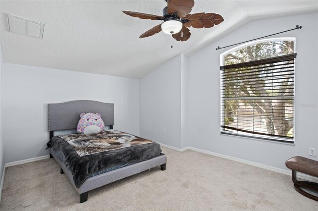 bedroom with ceiling fan, light colored carpet, vaulted ceiling, and multiple windows