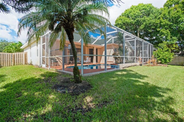 exterior space featuring a lanai, a fenced in pool, and a yard