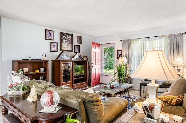 living room featuring a textured ceiling and light tile patterned floors