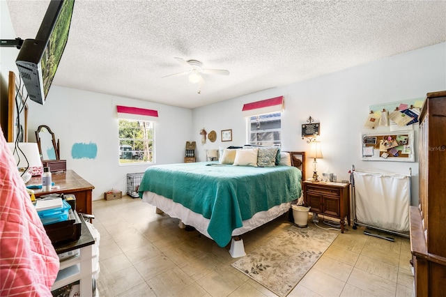 bedroom with ceiling fan and a textured ceiling