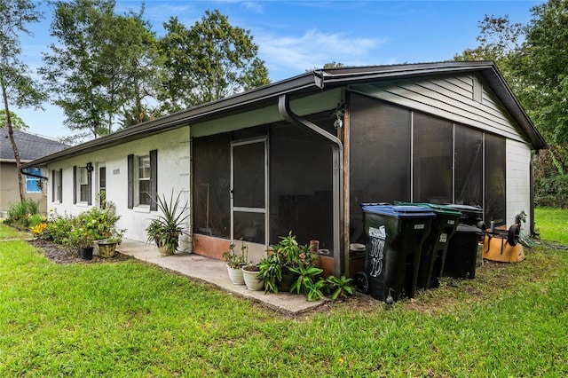 rear view of property with a sunroom and a yard