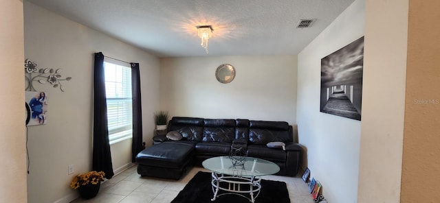 tiled living room featuring a textured ceiling