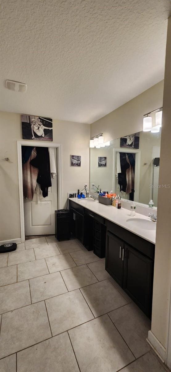 bathroom with vanity, a textured ceiling, and tile patterned floors