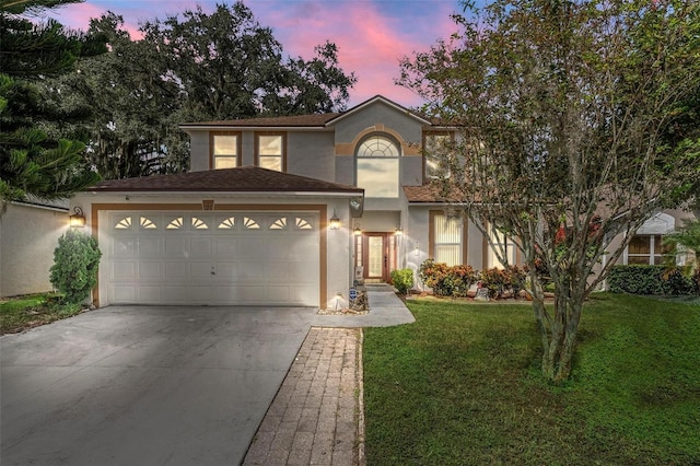 view of front of property with a yard and a garage