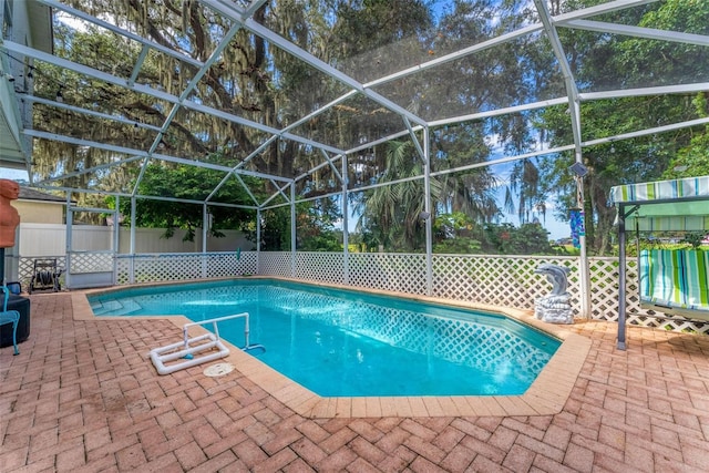 view of pool featuring glass enclosure and a patio