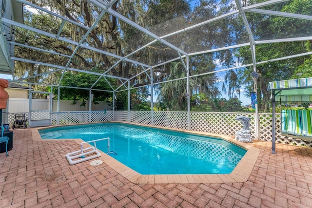 view of swimming pool with a patio, fence, a fenced in pool, and glass enclosure
