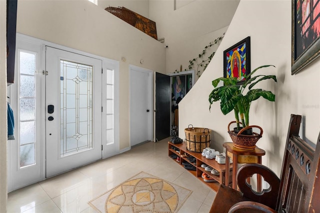 tiled entryway featuring a towering ceiling