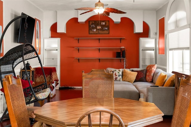 dining area featuring arched walkways and ceiling fan