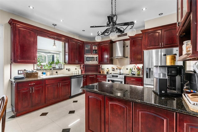 kitchen featuring hanging light fixtures, sink, wall chimney range hood, and stainless steel appliances