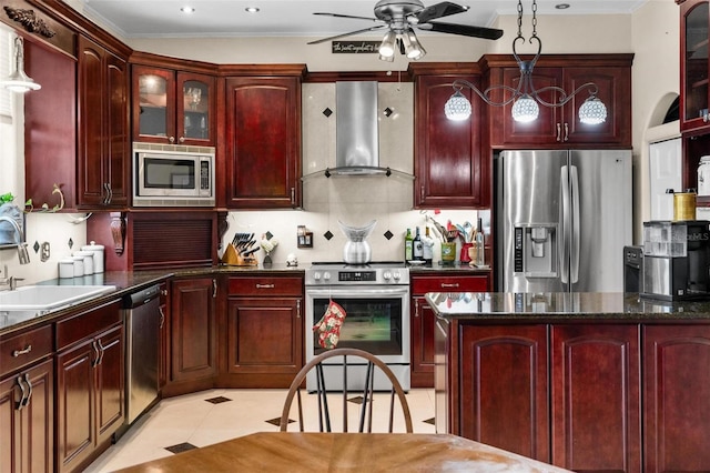 kitchen with crown molding, stainless steel appliances, wall chimney exhaust hood, dark brown cabinets, and a ceiling fan
