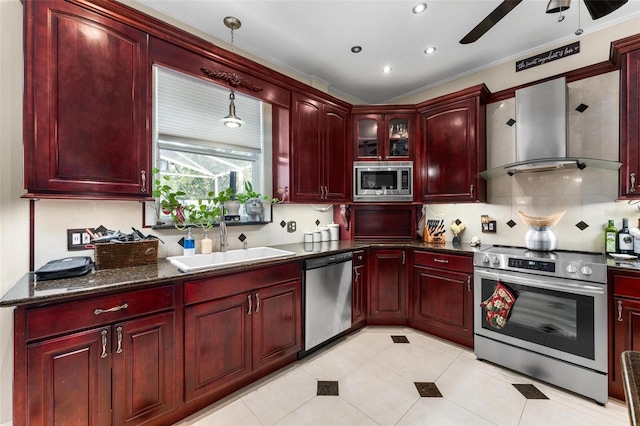 kitchen with appliances with stainless steel finishes, ceiling fan, ornamental molding, sink, and wall chimney range hood