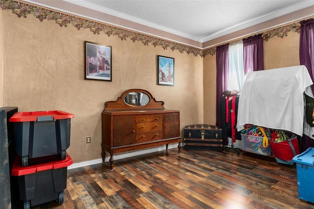 interior space featuring hardwood / wood-style floors, a textured ceiling, baseboards, and ornamental molding