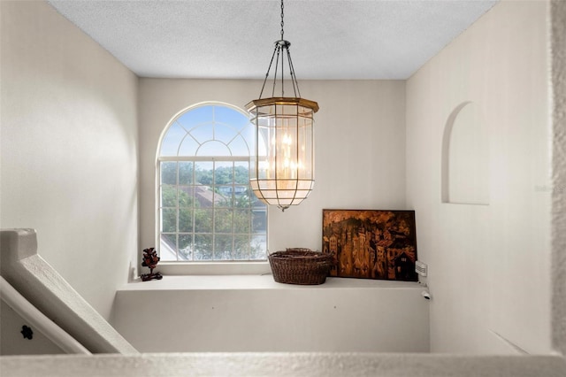 room details with a textured ceiling and a notable chandelier