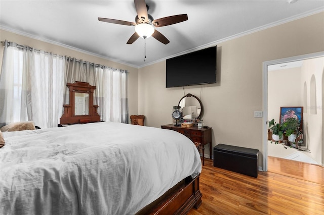 bedroom with ceiling fan, ornamental molding, and hardwood / wood-style floors