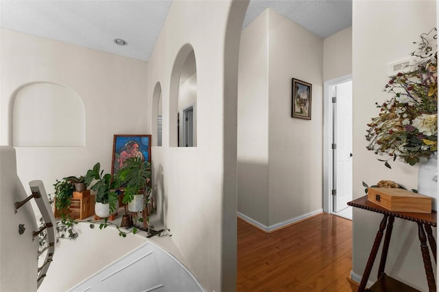 corridor featuring a textured ceiling and dark hardwood / wood-style floors