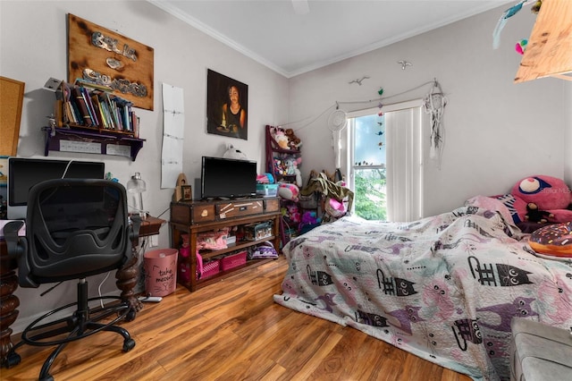 bedroom with ornamental molding, ceiling fan, and wood finished floors
