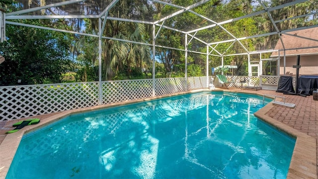 view of swimming pool featuring a lanai and a patio area