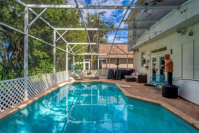outdoor pool with french doors, a lanai, and a patio area
