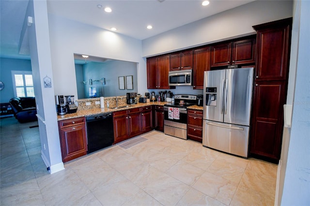 kitchen with light stone countertops, sink, and stainless steel appliances