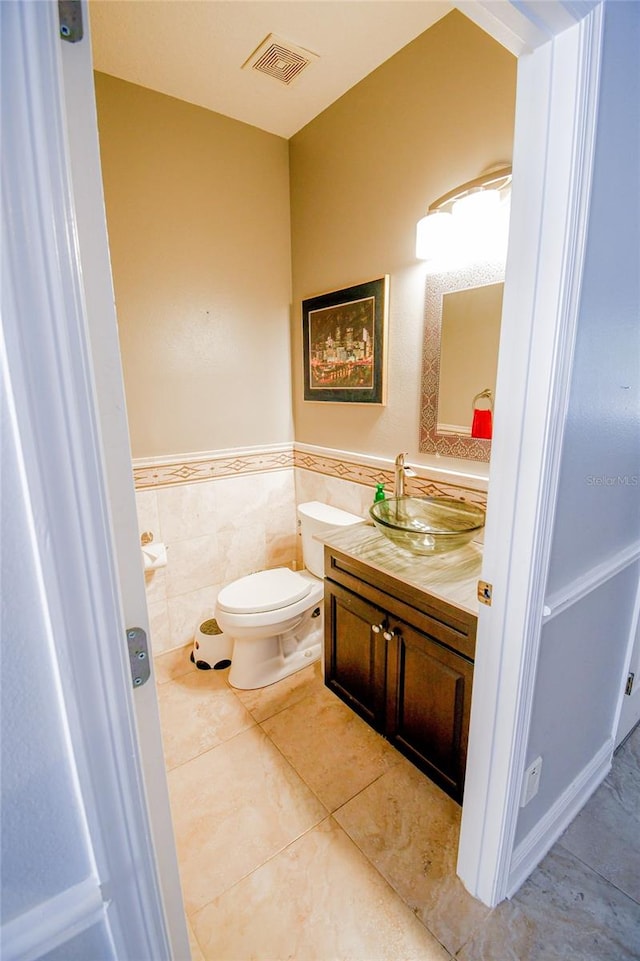 bathroom featuring tile walls, tile patterned flooring, vanity, and toilet