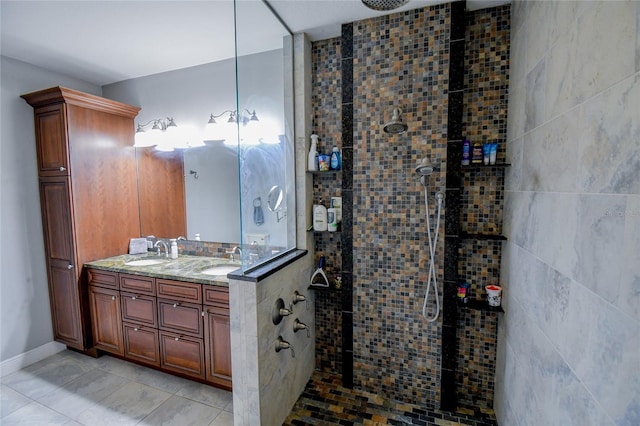 bathroom with tiled shower, vanity, and tile patterned floors