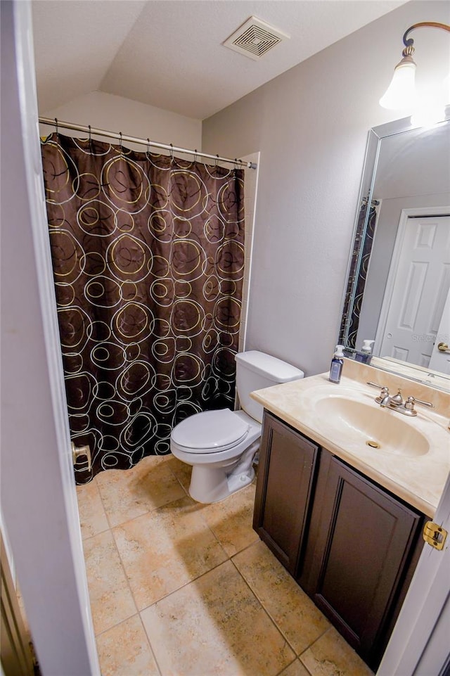 bathroom featuring lofted ceiling, vanity, toilet, and tile patterned floors