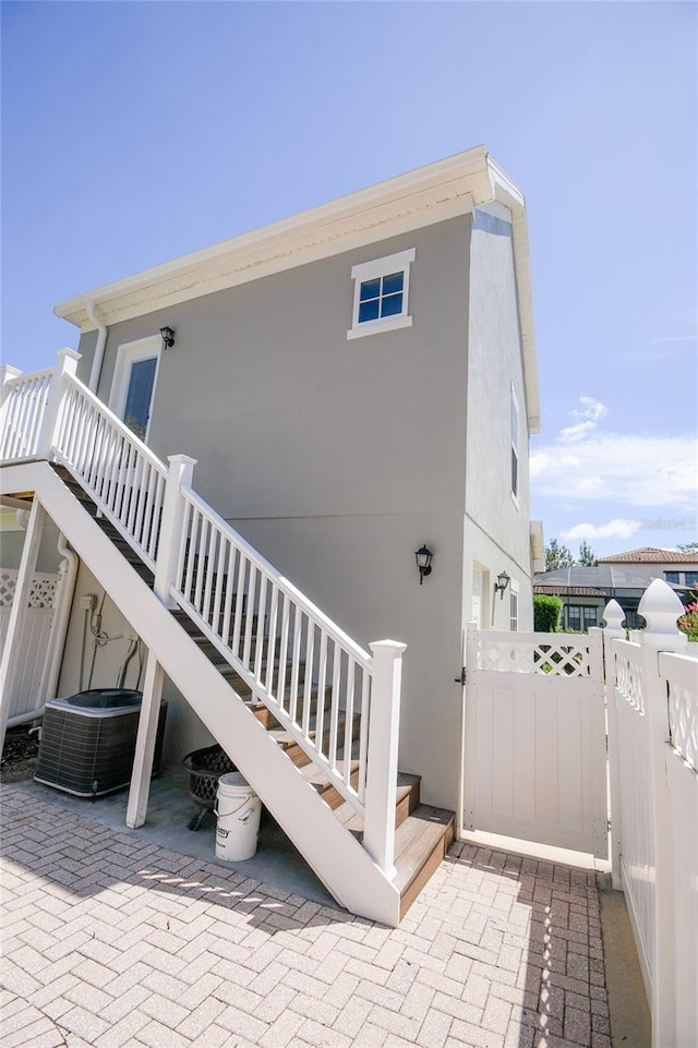 view of side of home with central AC and a patio area