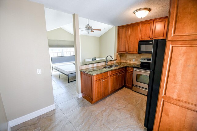 kitchen featuring ceiling fan, lofted ceiling, sink, black appliances, and dark stone countertops