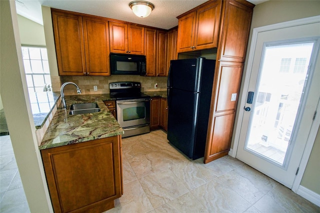 kitchen with sink, a textured ceiling, backsplash, black appliances, and dark stone counters