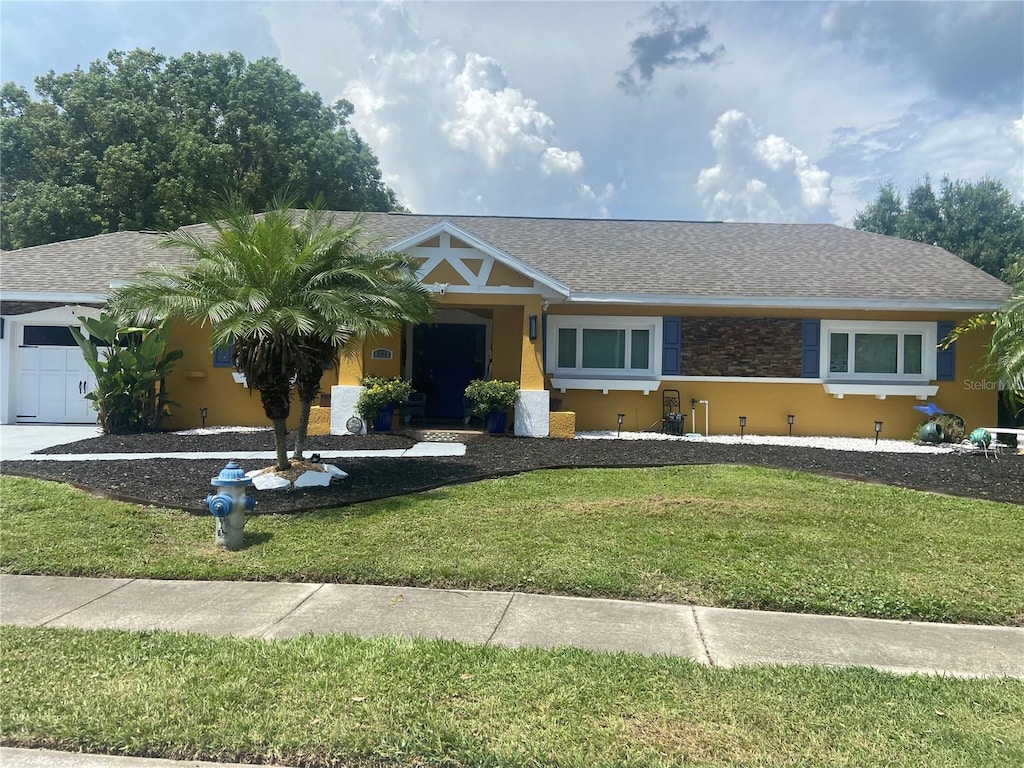 single story home with a front yard and a garage