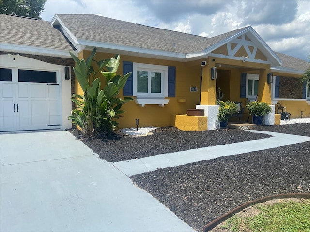 ranch-style home with a garage, driveway, and a shingled roof