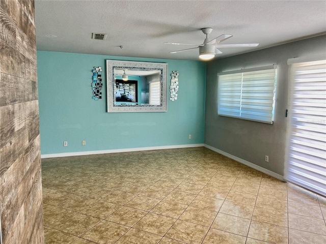 unfurnished room with visible vents, plenty of natural light, and a textured ceiling