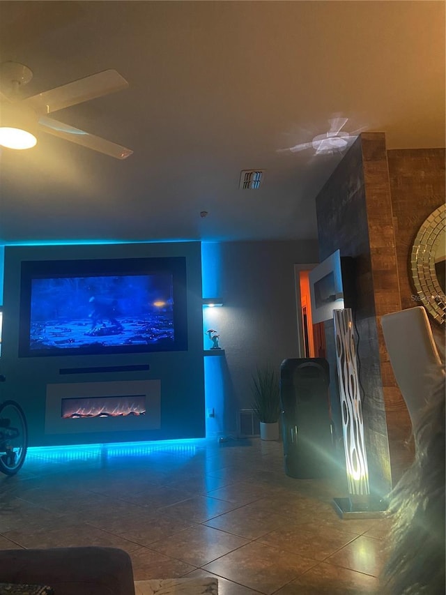 tiled living room with a glass covered fireplace and visible vents