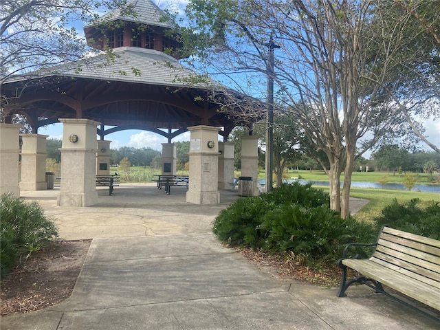 surrounding community with a water view and a gazebo