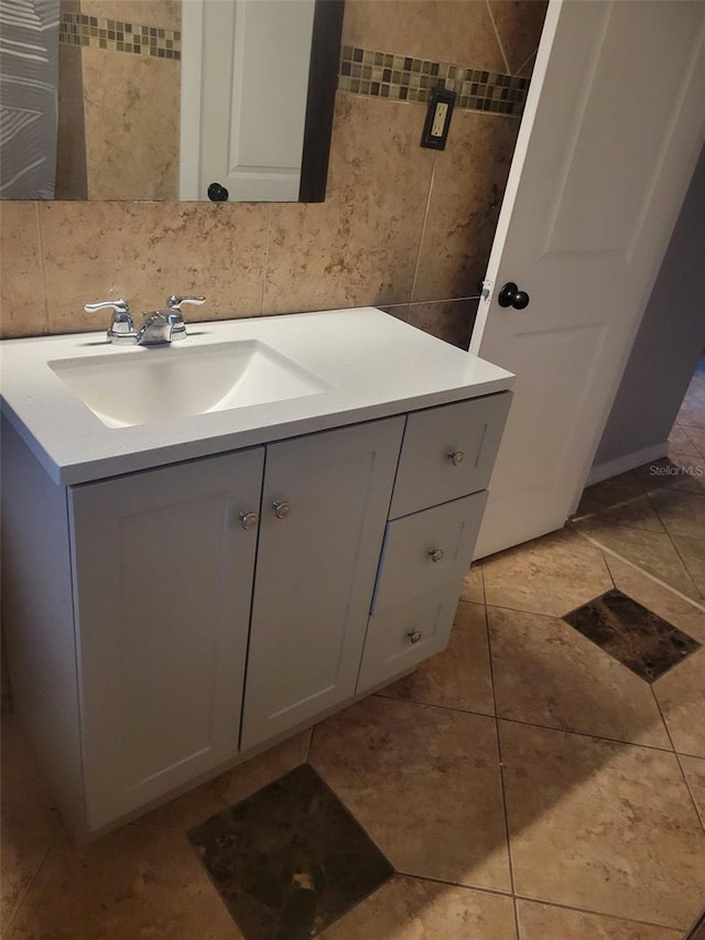 bathroom featuring tile patterned flooring, vanity, and tile walls