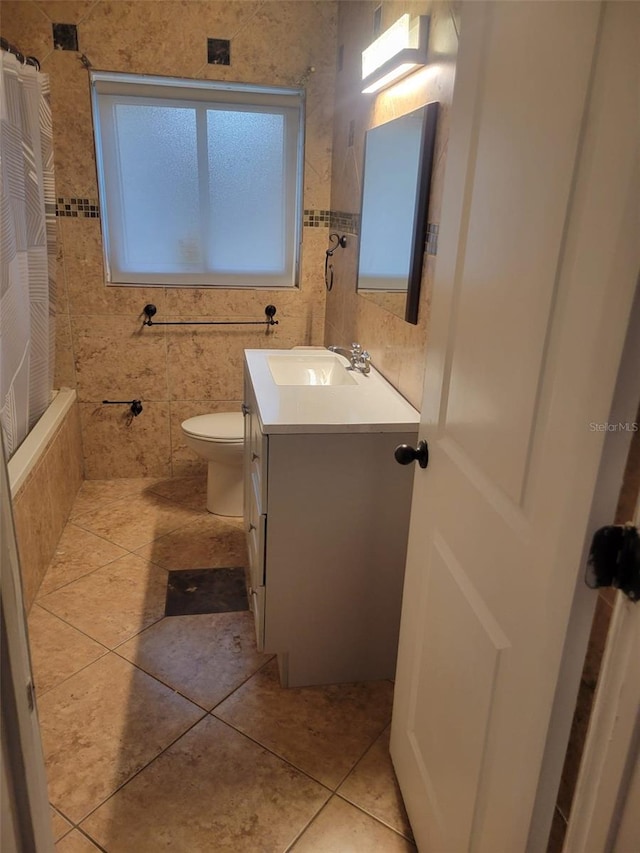 full bath with toilet, tiled shower / bath, vanity, and tile patterned flooring