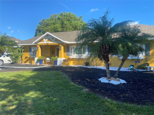 view of front of home featuring a front yard and stucco siding