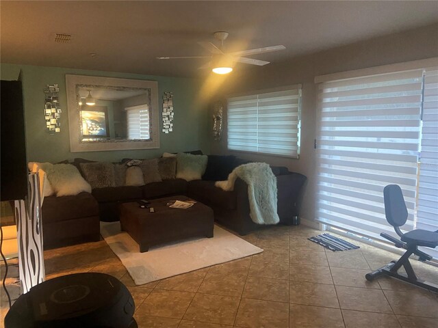 tiled living area with ceiling fan, visible vents, and a wealth of natural light