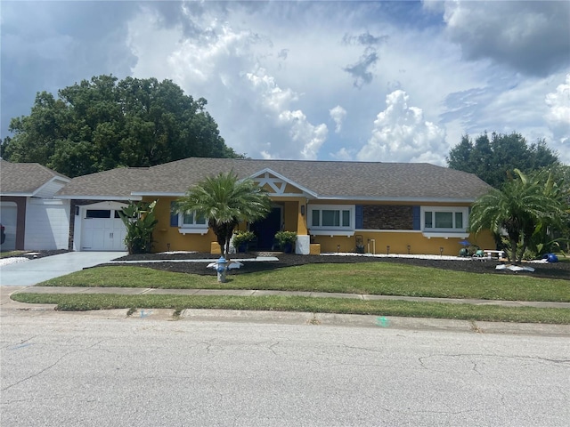 ranch-style house featuring an attached garage, concrete driveway, stucco siding, and a front lawn