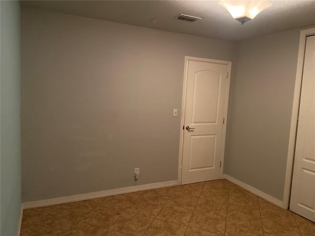 unfurnished room featuring visible vents, baseboards, and light tile patterned floors