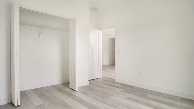 unfurnished bedroom with light hardwood / wood-style flooring and a closet