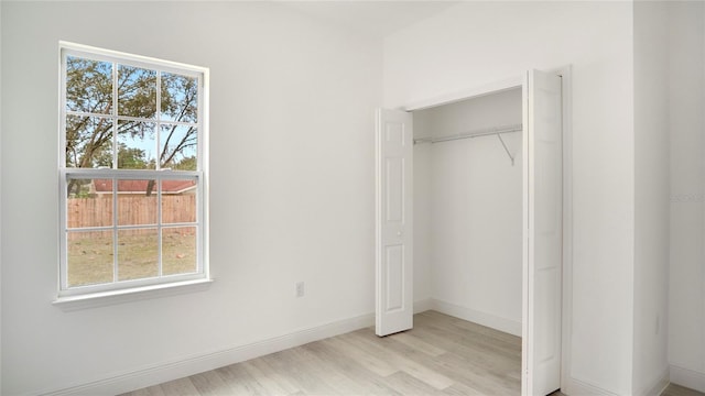 unfurnished bedroom with a closet and light hardwood / wood-style floors