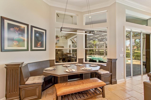 dining space with a high ceiling and crown molding