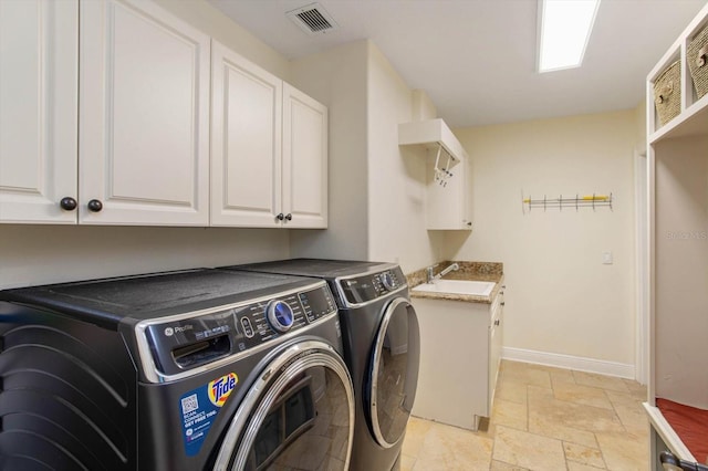 washroom with washing machine and clothes dryer, cabinets, and sink