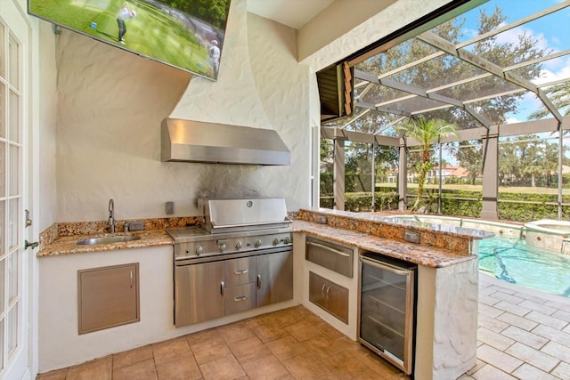 view of patio featuring area for grilling, a grill, a lanai, beverage cooler, and sink